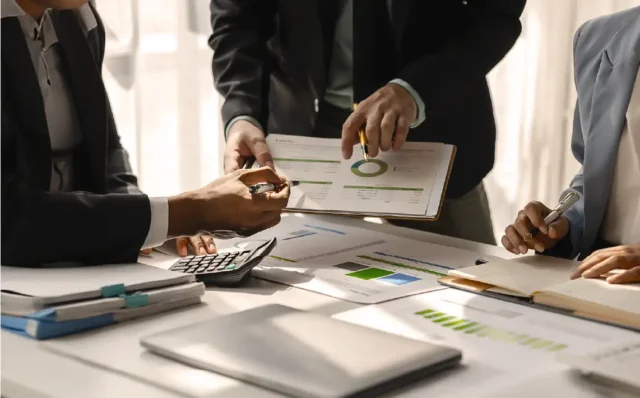Profesionales de negocios analizando informes financieros y gráficos circulares en una reunión