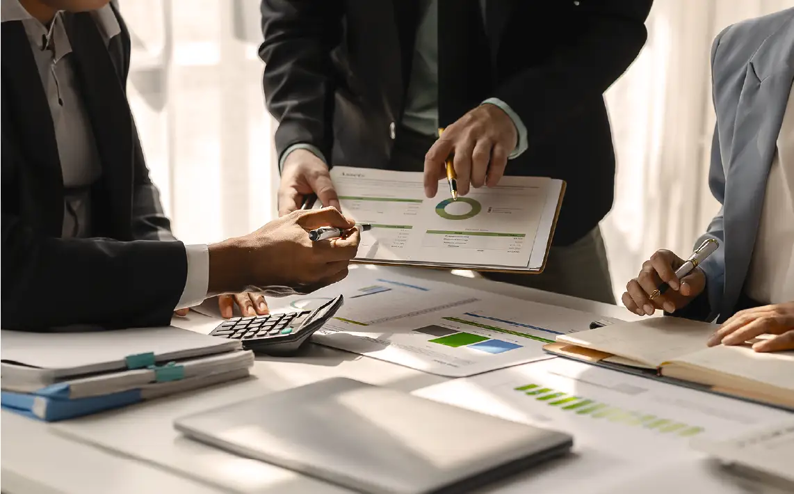 Profesionales de negocios analizando informes financieros y gráficos circulares en una reunión